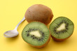 kiwis with spoon on yellow