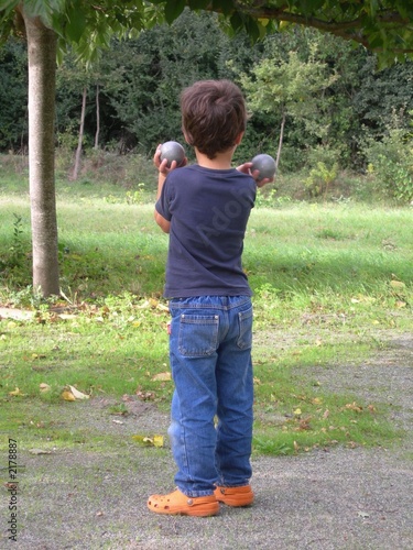 Photo: jeune garçon portant des boules de pétanque jeune garçon portant des boules de pétanque