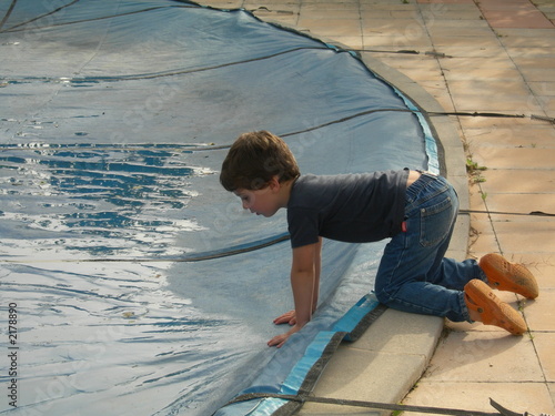 Photo: jeune garçon se penchant au dessus d'une piscine jeune garçon se penchant au dessus d'une piscine