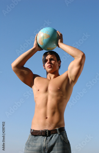 young muscular man playing with a terrestrial globe