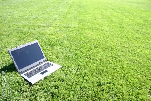 Photo: silver laptop on green grass silver laptop on green grass