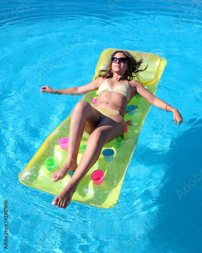 Photo: attractive, slim young lady lying on inflatable su attractive, slim young lady lying on inflatable su