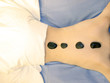   	spa: a girl takes a hot stones massage