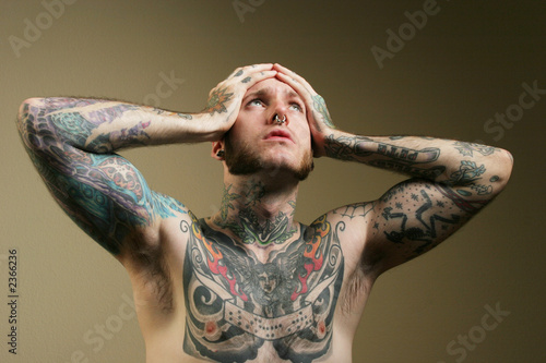 tattooed man holding his head