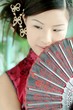 asian girl in red chinese dress holding a fan