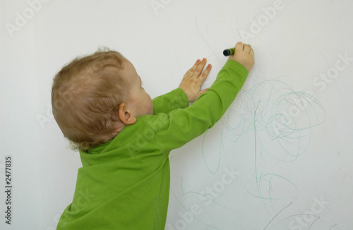 little child drawing on the wall