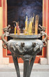 burning incense sticks at a temple.