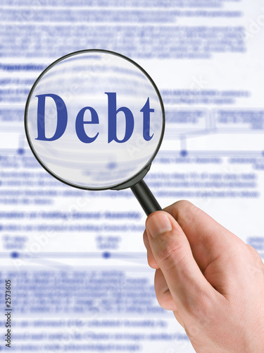 Photo: word debt, magnifying glass in hand word debt, magnifying glass in hand