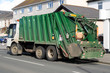 green rubbish truck with boxes in the back.