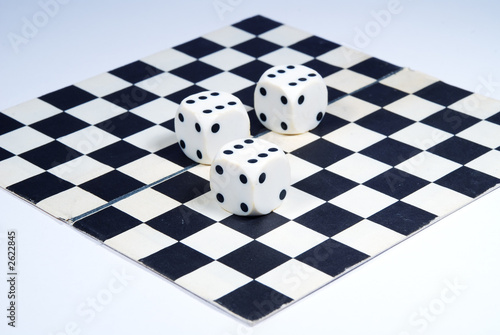 Photo: 3 dice on a chess-board, isolated on a white background 3 dice on a chess-board, isolated on a white background