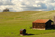 a lone barn and shed on a california hillside