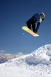 snowboarder in blue jacket jumping high - winter mountain action