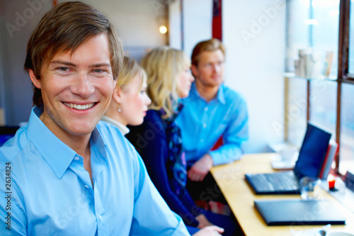 portrait of a young man in front of a workgroup