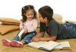 brother and sister reading books on the floor