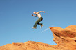 man jumping on red rocks