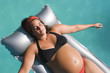 pregnant woman laid on a floating mattress
