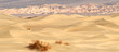 rolling sand dunes with mountains in death valley california at