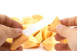 pair of hands opening a fortune cookie with blank