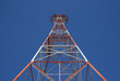 red triangular power tower in the blue sky