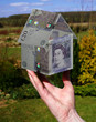 hand holding £20 house