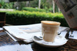 cup of coffee with news paper on table