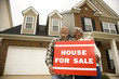 Photo: middle-aged couple holding a for sale sign. middle-aged couple holding a for sale sign.