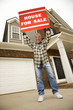 Photo: middle-aged man holding a for sale sign. middle-aged man holding a for sale sign.