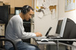 man sitting at desk with computers.