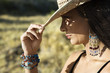 young woman tipping a cowboy hat.