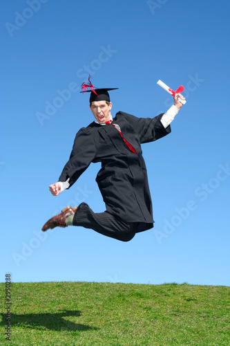 male graduate leaping for joy outdoors