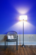 Photo: lamp and chair with book against blue wall. lamp and chair with book against blue wall.