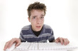 Foto: confused teenage boy using computer confused teenage boy using computer