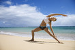 Woman stretching on beach.