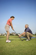 Foto: Man teaching woman proper golf techniques. Man teaching woman proper golf techniques.