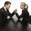 man and woman arm wrestling on table.