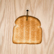 slice of toast nailed to wood.