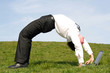 businessman bending over backwards and using lapto