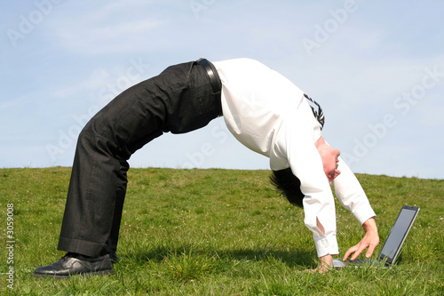 businessman bending over backwards and using lapto