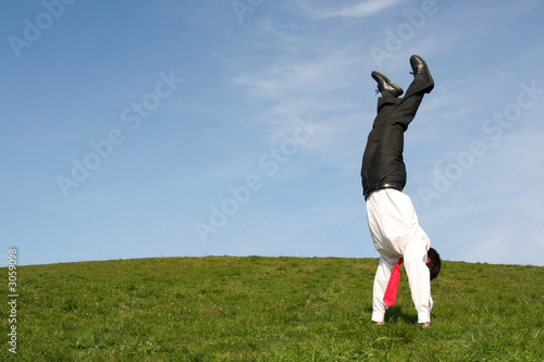 businessman doing handstand outdoors