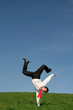 businessman doing one handed handstand outdoors