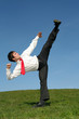 businessman kicking in kung fu pose outdoors