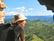 a trekker woman with a hat looking over the mountains and the ju