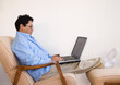 asian man relaxing with laptop