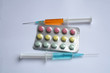 orange and blue syringes and tablets