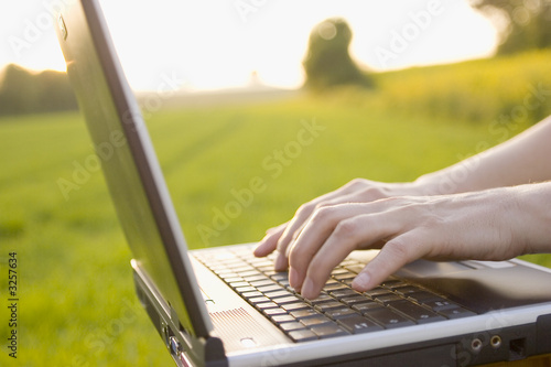 typing on a laptop outside