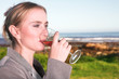 woman drinking wine next to the ocean