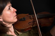mid-age woman playing violon over black mid-age woman playing violon over black