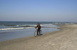 young lady cycling on the beach