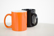 orange and black coffee mugs with white background