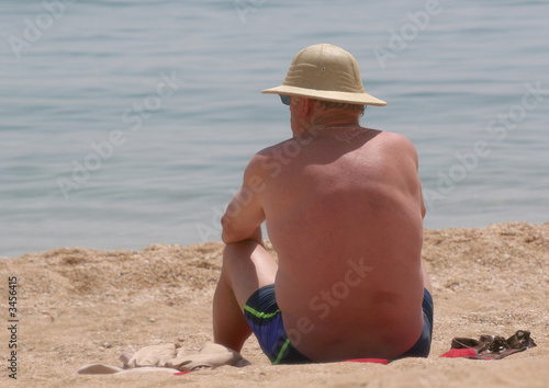 Photo: homme assis sur la plage homme assis sur la plage